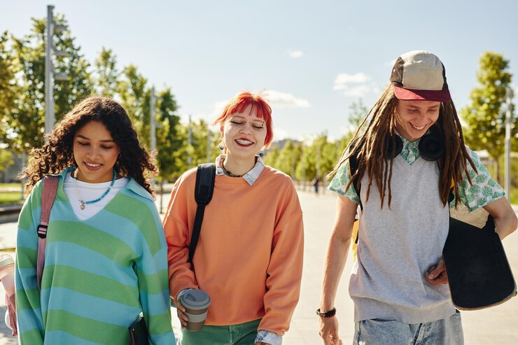 Photo three smiling multiethnic teenagers walking together in park on sunny day