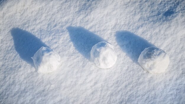 写真 晴れた日に雪の上に横たわる 3 つの雪玉