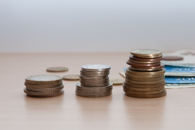 Three stacks of coins and bills lie on the table.