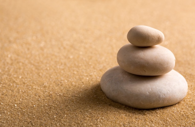 Photo three staked stones on sand