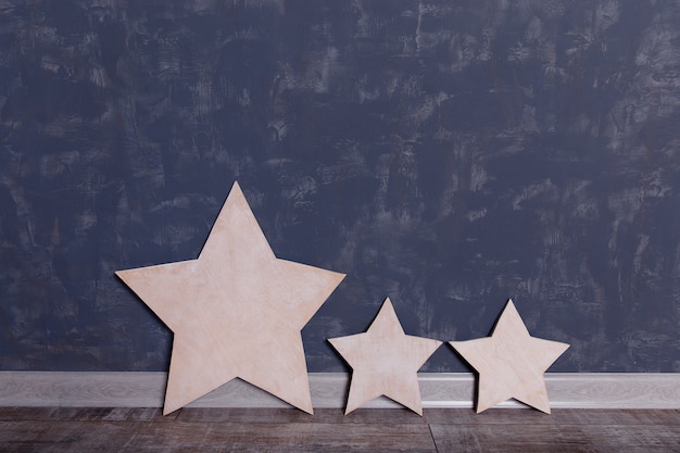 Three stars of wood on a wall.