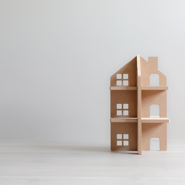 Three-storey wooden toy house in bright room with copy space. 