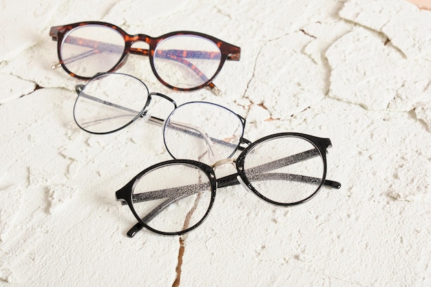 Three stylish modern eye glasses on cracked background