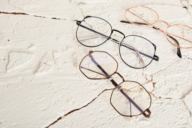 Three stylish modern eye glasses on cracked background