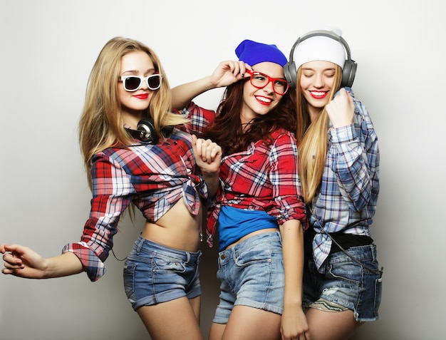 Foto tre migliori amiche di ragazze hipster sexy alla moda. stare insieme e divertirsi. su sfondo grigio.