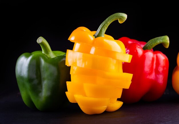 Three sweet peppers on a wooden background,