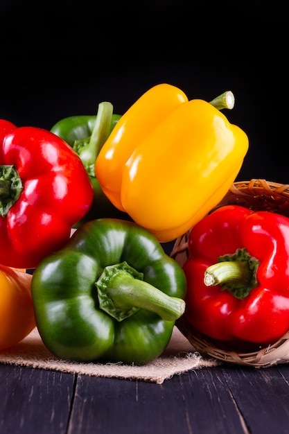 Three sweet peppers on a wooden background,