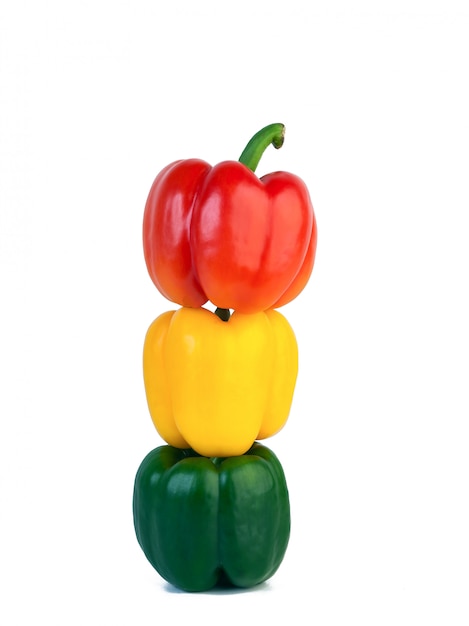 Three sweet red peppers, yellow and green on isolated white