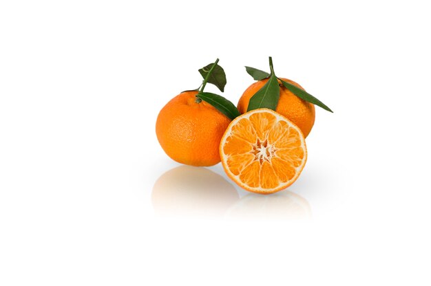 Three Tangerine or clementine with green leaf isolated with reflection on white surface.