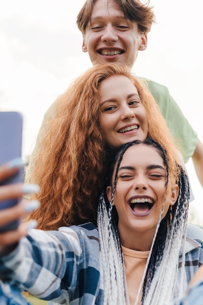 Foto tre adolescenti si divertono e si fanno selfie godendosi una giornata all'aperto app per social media ritratto di bellezza