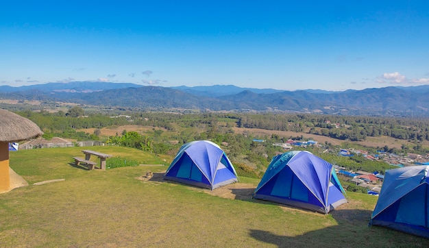 Three tents of blue on the high hills. 