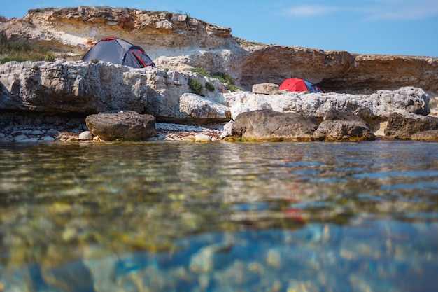 Three tents on the seashore. View from the water