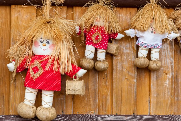 Three textile dolls in red and white Tshirts with small wooden boxes.