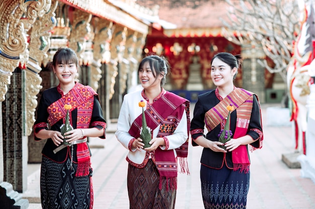 Три тайские девушки в племени Фу Тай, стоящие в районе тайского храма