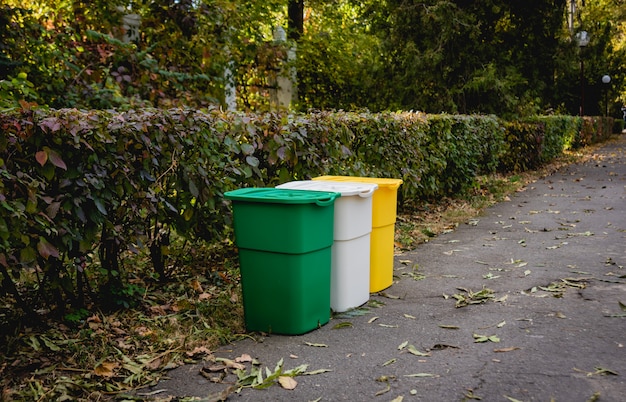 Three trash containers in different color, for sorted waste. Outdoors in the park zone. Zero waste concept