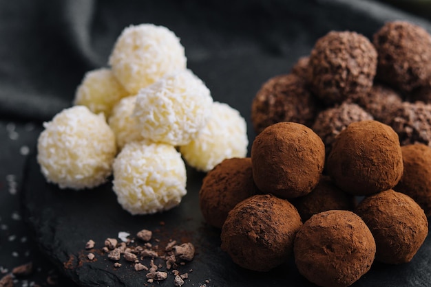 Three types of chocolate balls on stone board