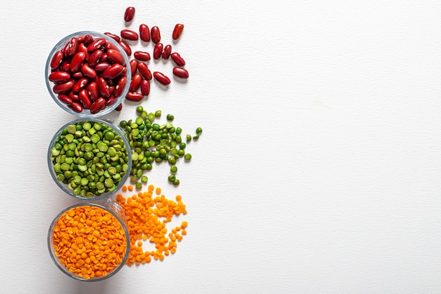 Three types of legumes, beautifully laid out in cups and on white. Top view. copy space. 