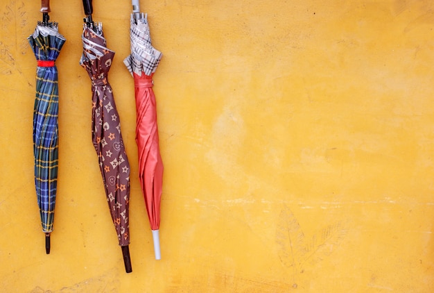 three umbrellas hanging against the grunge wall