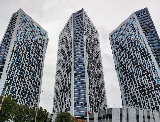 Three unfinished highrise buildings next to each other for the entire frame View from below