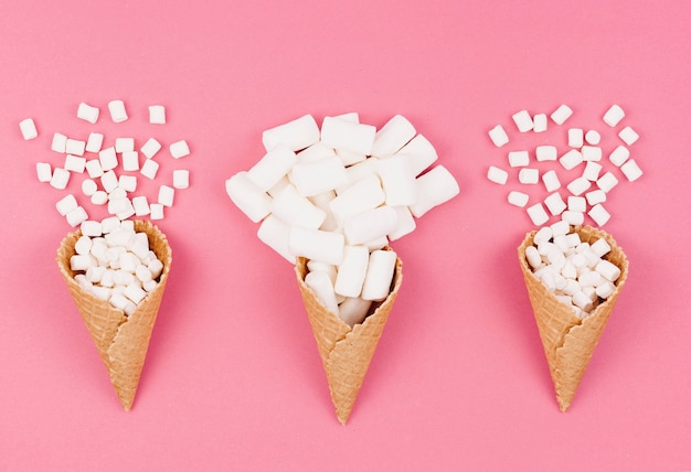 Photo three waffle cones with marshmallows on table