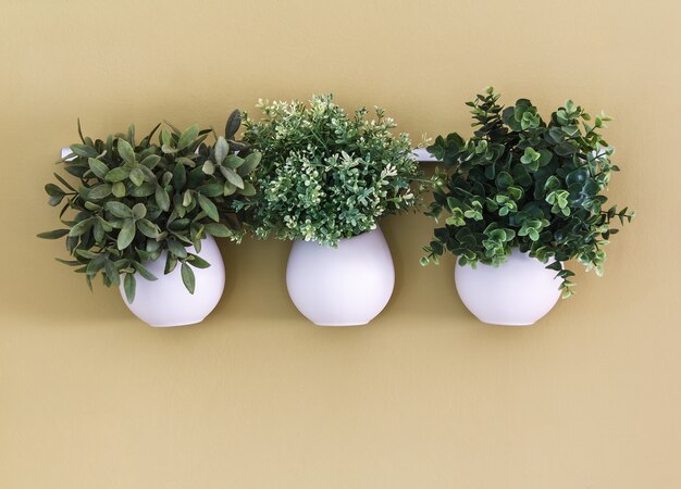 Three white flower pot with flowers hanging on the wall