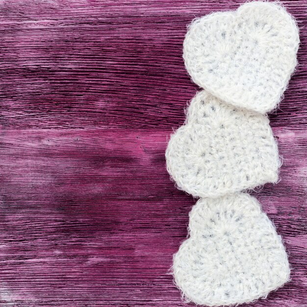 Three white hearts on wooden background