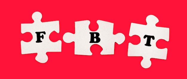 밝은 빨간색 배경에 FBT Fringe Benefit Tax라는 텍스트가 있는 흰색 직소 퍼즐 3개