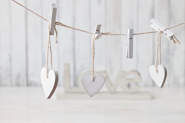 Three white wooden hearts  on the rope. Love concept for the Valentine's Day