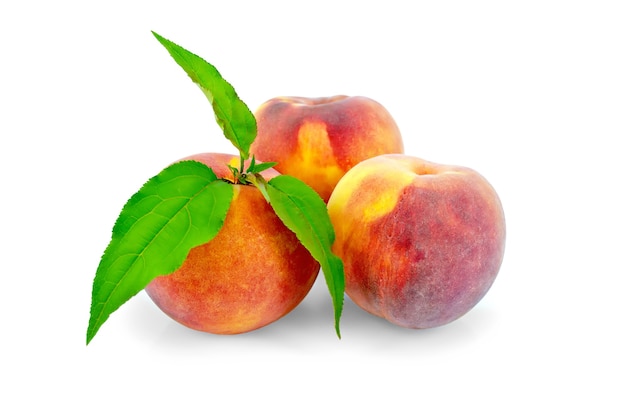 Three whole peaches, green leaves isolated  