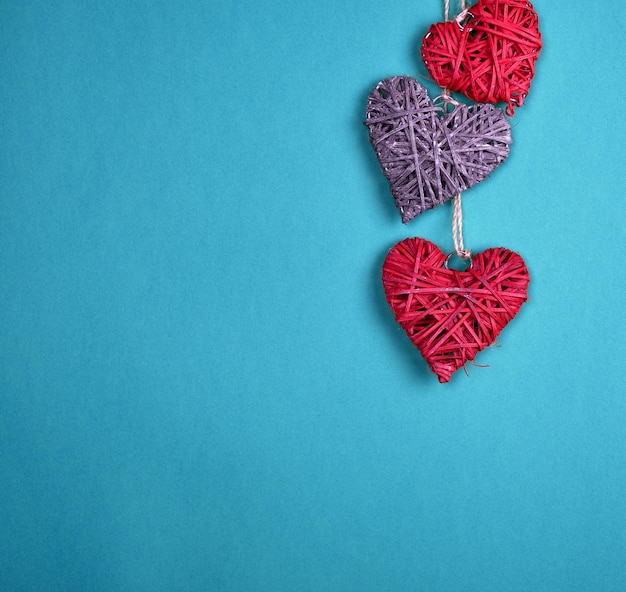 three wicker hearts hang on a rope