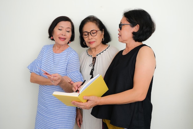 Photo three women are in a serious talk one of them holding a book