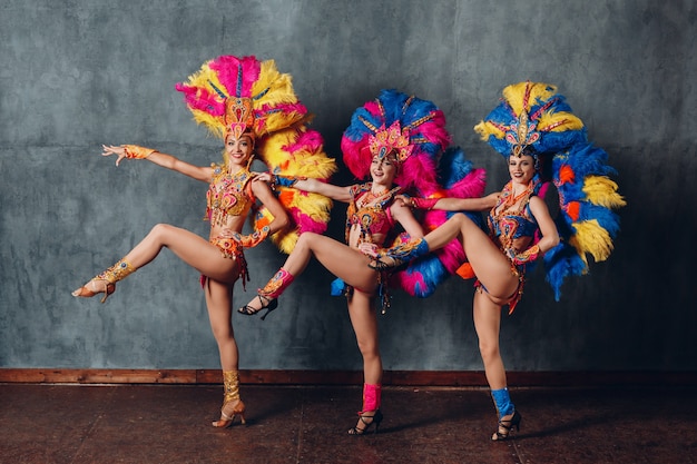 Three Women in cabaret costume with colorful feathers plumage