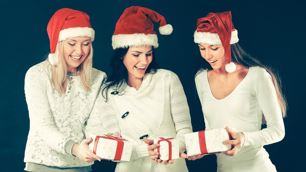 Three women in costume of Santa Claus with Christmas shopping