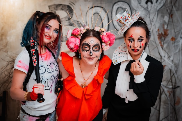 Three women female friends with creepy makeup celebrating halloween holiday together