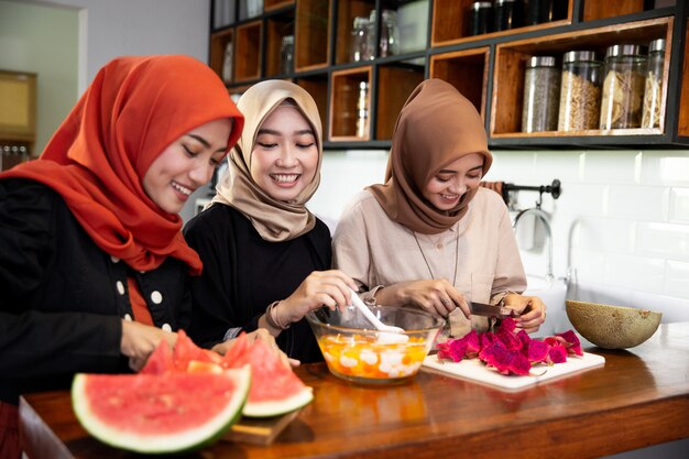 Three women hijab enjoy preparing food for breaking fast serve