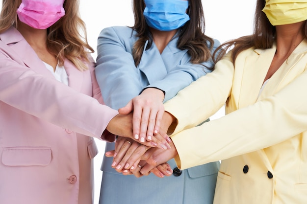 three women in pastel suits posing over white background