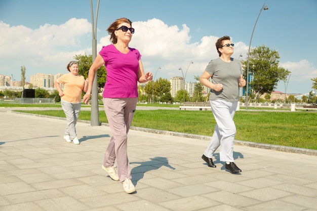 Three women running in public park having healthy lifestyle for immunity