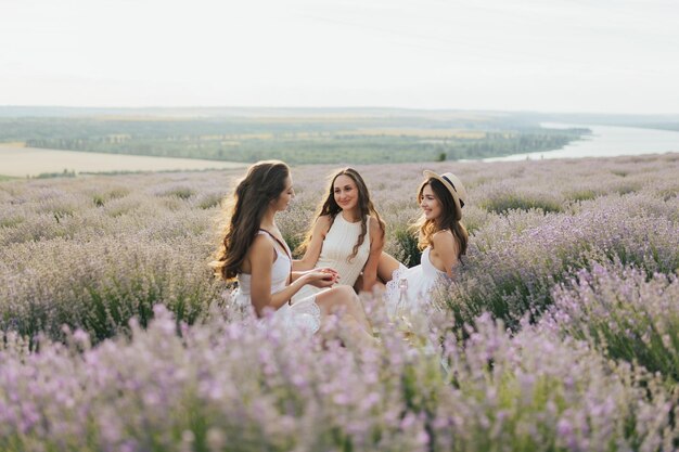 Three women sitting in a field of lavender