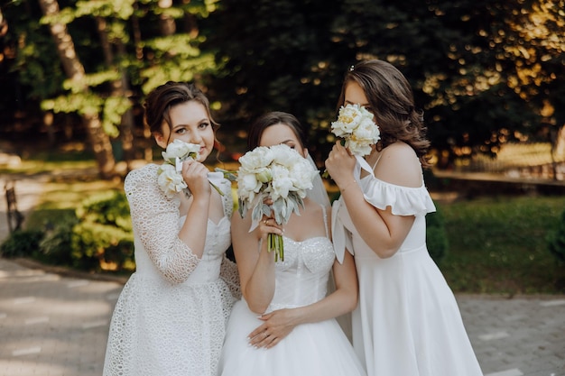 Three women in white dresses are posing for a photo