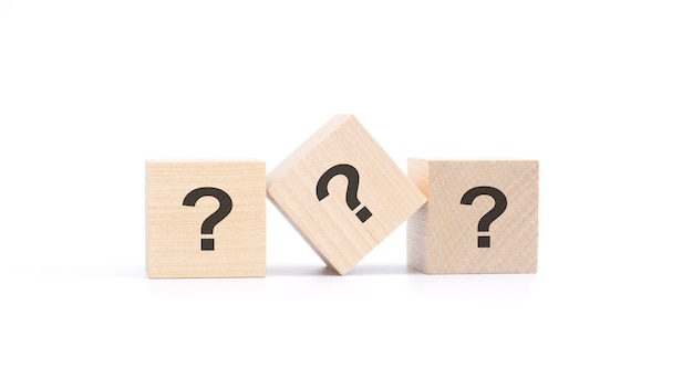 Photo three wooden blocks with a question mark top view on a white background