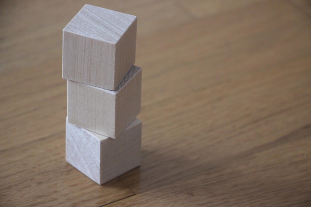 Three wooden cubes pt vertically on table background