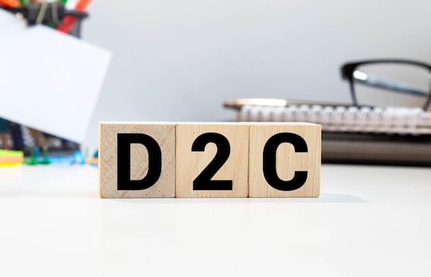 写真 d2cの文字が付いた木製の立方体が3つあり白いテーブルにチャートが付いています
