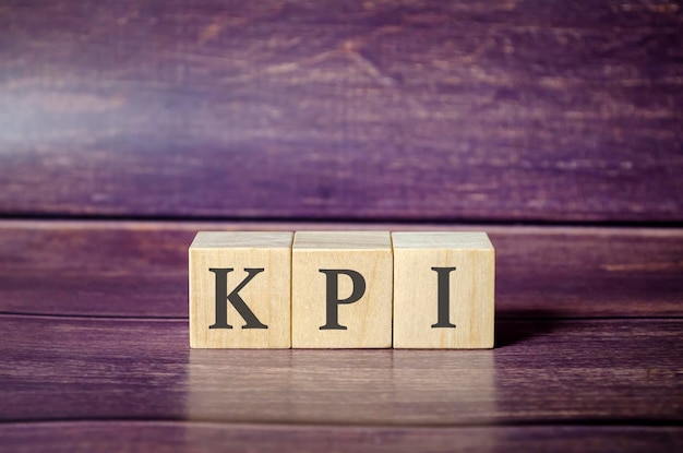 Three wooden cubes with letters KPI on the wooden table
