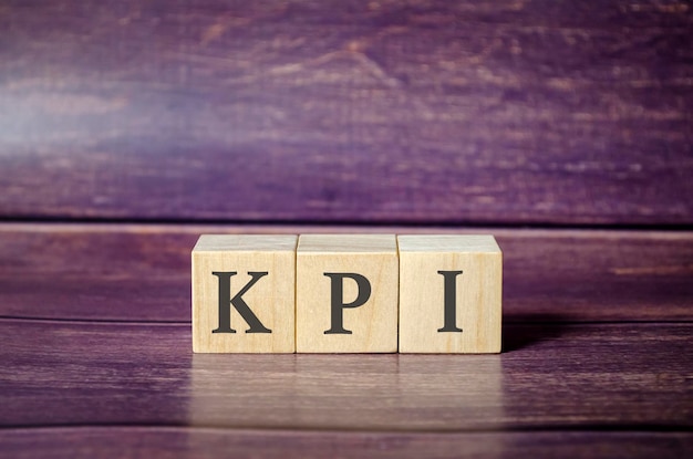 木製のテーブルに文字 KPI を持つ 3 つの木製キューブ