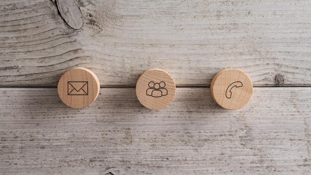 Three wooden cut buttons with contact and communication icons on them