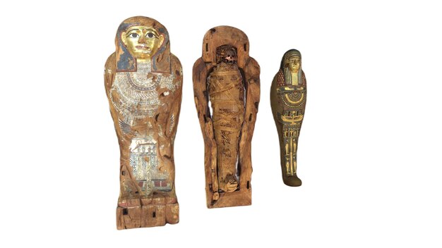 Three wooden statues of an egyptian mummy, one of which is from the museum of the dead.