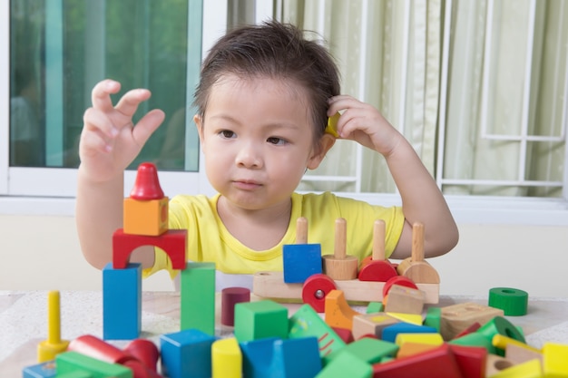 three-year child plays with toy blocks