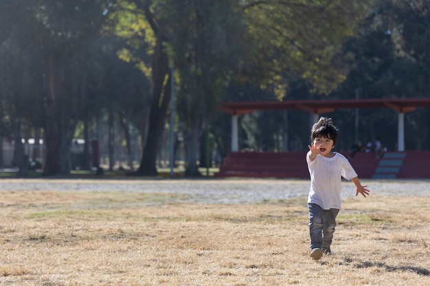 Three year old mexican boy playing and running in the park