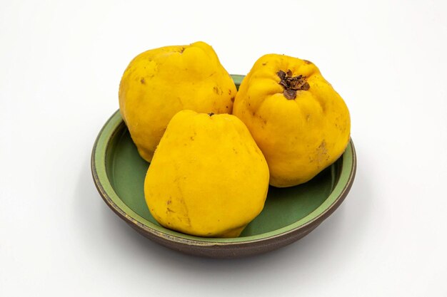 Photo three yellow fruits on a green plate