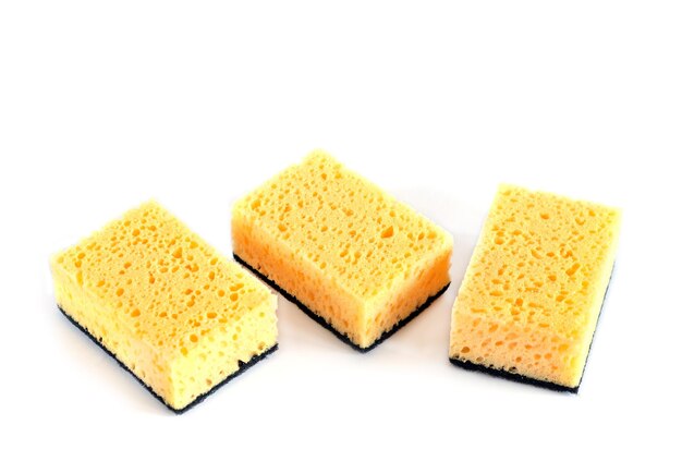 Three yellow sponges for washing dishes and other domestic needs isolated on white background